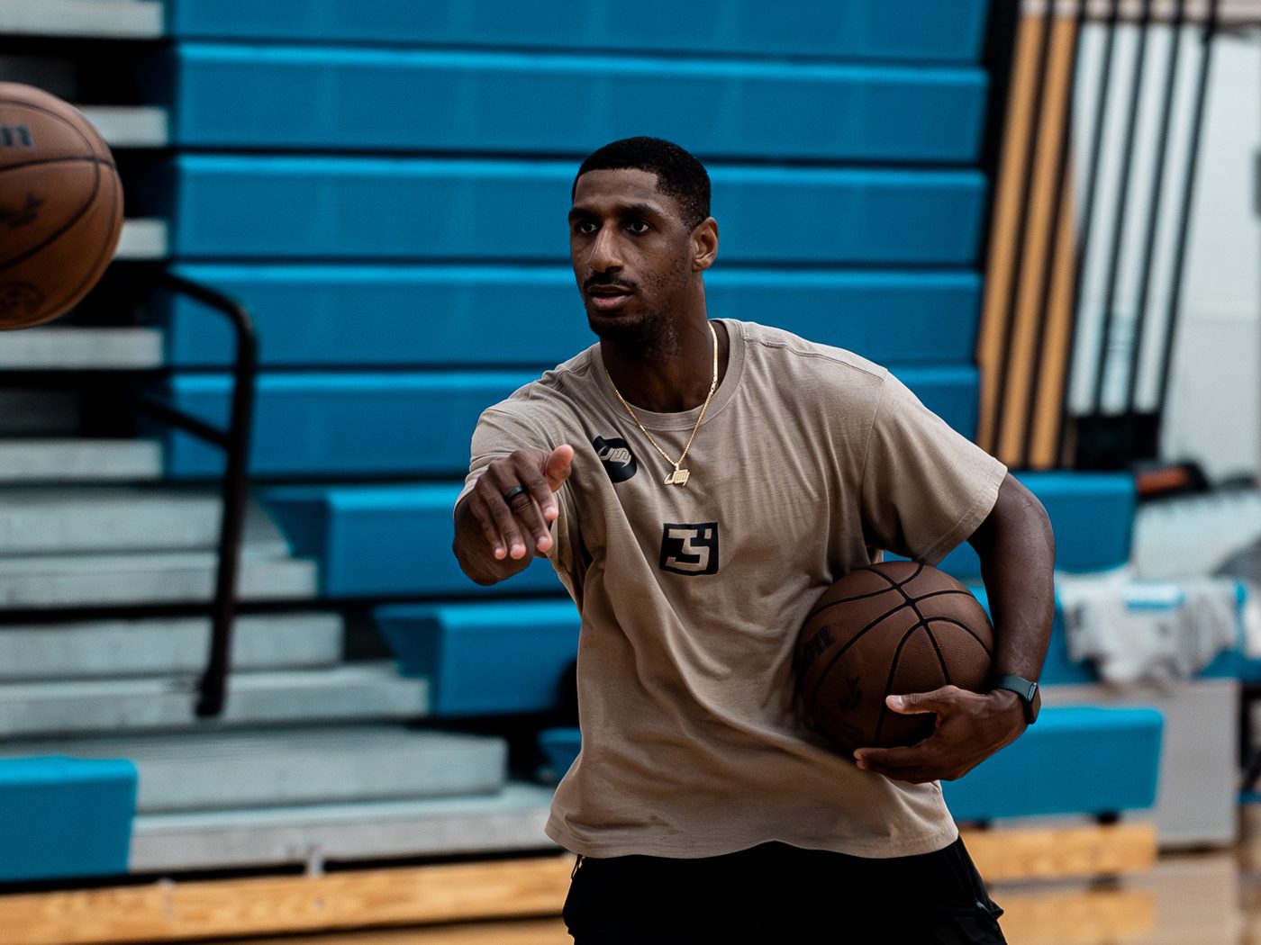 Jeremiah M. Williams passing a basketball during a gym training session